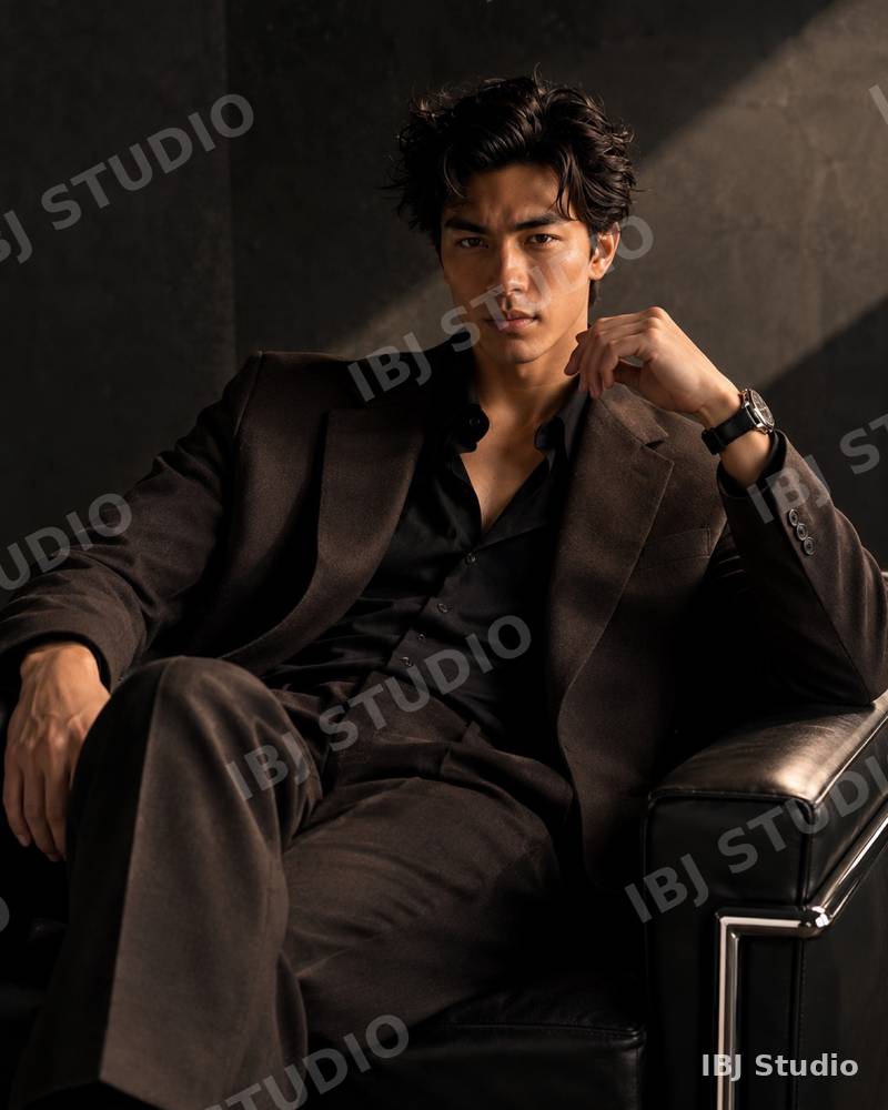 Editorial portrait of a man in a dark suit in an armchair